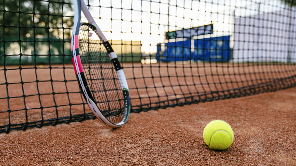 Professor orientando a postura e a empunhadura da raquete de um aluno durante o treino na conceituada escola de tênis em Jundiaí da VtennisTeam.